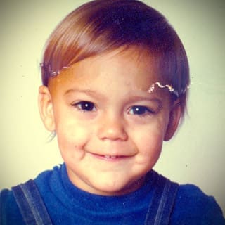 Marco Enríquez-Ominami en su infancia, fotografía de cuando era bebé con una sonrisa y polera azul.