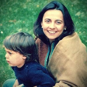 Marco Enríquez-Ominami de niño junto a su madre Manuela Gumucio, sentados sobre el pasto en una escena familiar.