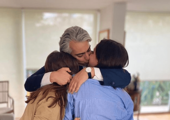 Marco Enríquez-Ominami abrazando con ternura a sus hijas, en una escena familiar llena de afecto y cercanía.